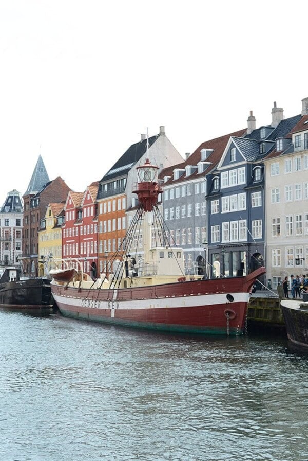 a boat docked next to a row of colorful buildings.