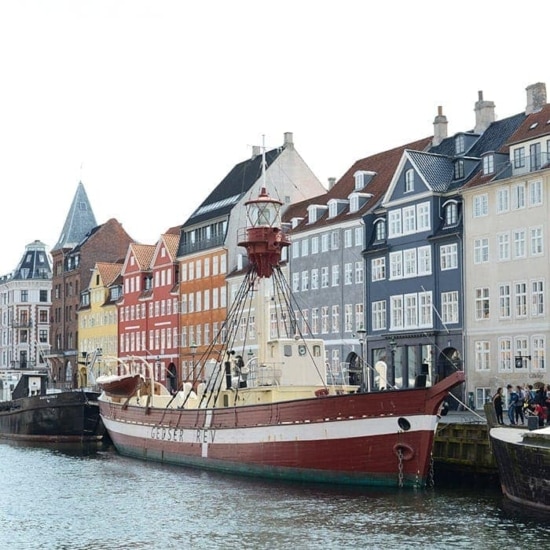 a boat docked in front of a row of colorful buildings.