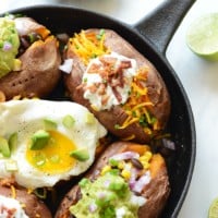 Stuffed sweet potatoes with eggs in a skillet.