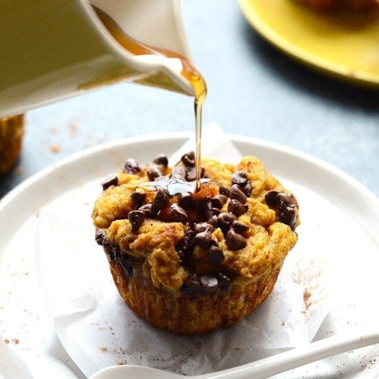 Pumpkin French toast cups being drizzled with honey.