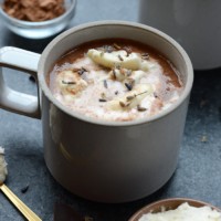 A mug of honey lavender hot chocolate with marshmallows and whipped cream.