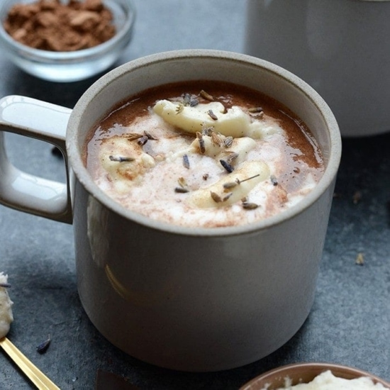 a mug of Honey Lavender Hot Chocolate with whipped cream and bananas.
