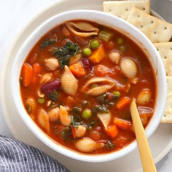 A bowl of Minestrone Soup served with crackers.