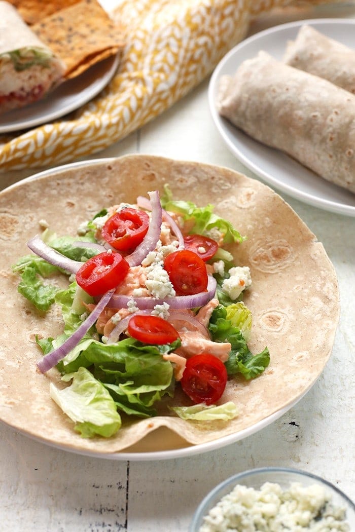 gesunde Hühnerpackung Zutaten auf Tortilla einschließlich Tomaten, Zwiebeln und Büffelhuhn