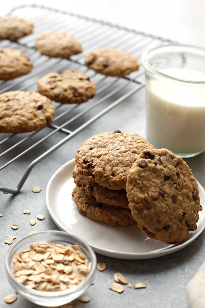 Healthy oatmeal cookies on a plate next to a glass of milk.