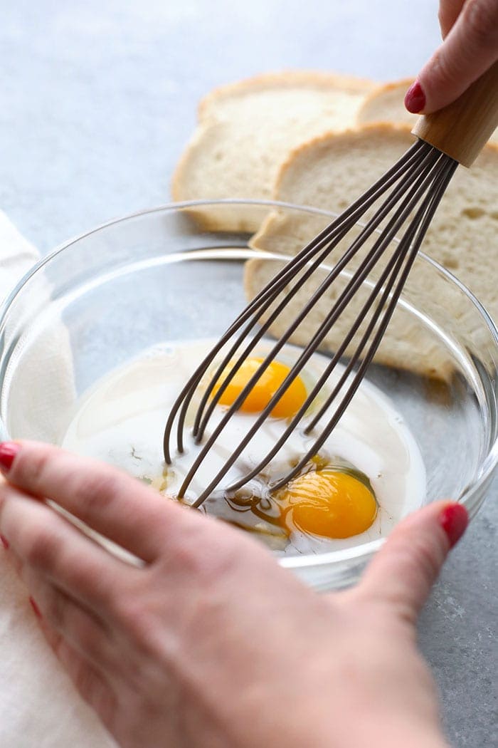 whisking eggs and milk in bowl