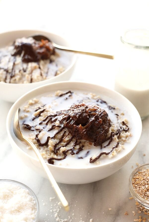 Two bowls of steel cut oatmeal with chocolate sauce.