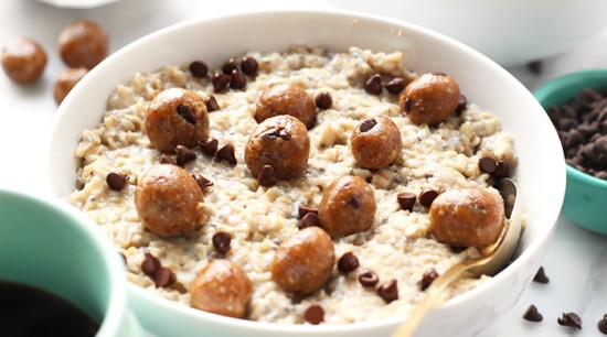 A bowl of Chocolate Chip Cookie Dough Oatmeal accompanied by a cup of coffee.