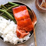 honey sriracha salmon on plate with rice and green beans and fork