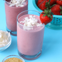 Two glasses of smoothie with strawberries and coconut.
