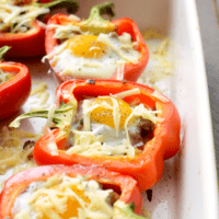 Stuffed peppers with eggs and cheese on a baking sheet.