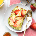 A plate of toast with strawberries and guacamole.