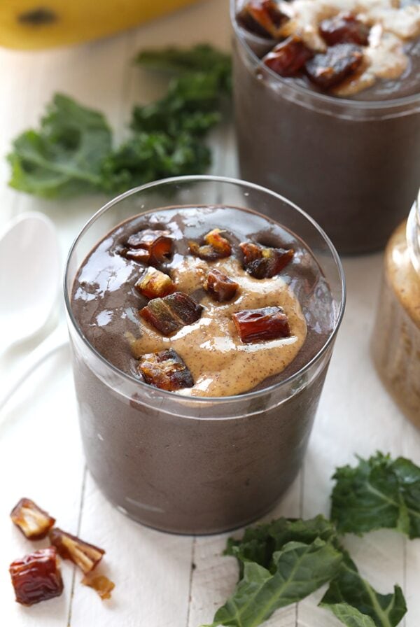 chocolate protein date smoothie in glass with dates on top