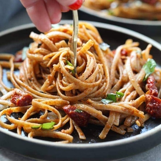 sun dried tomato pasta being twirled on fork