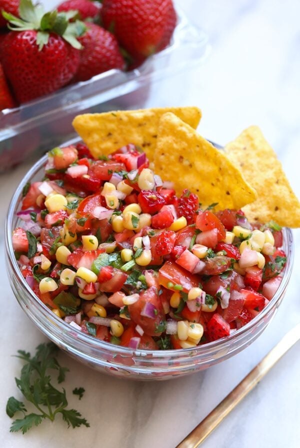 a bowl of strawberry salsa with tortilla chips.