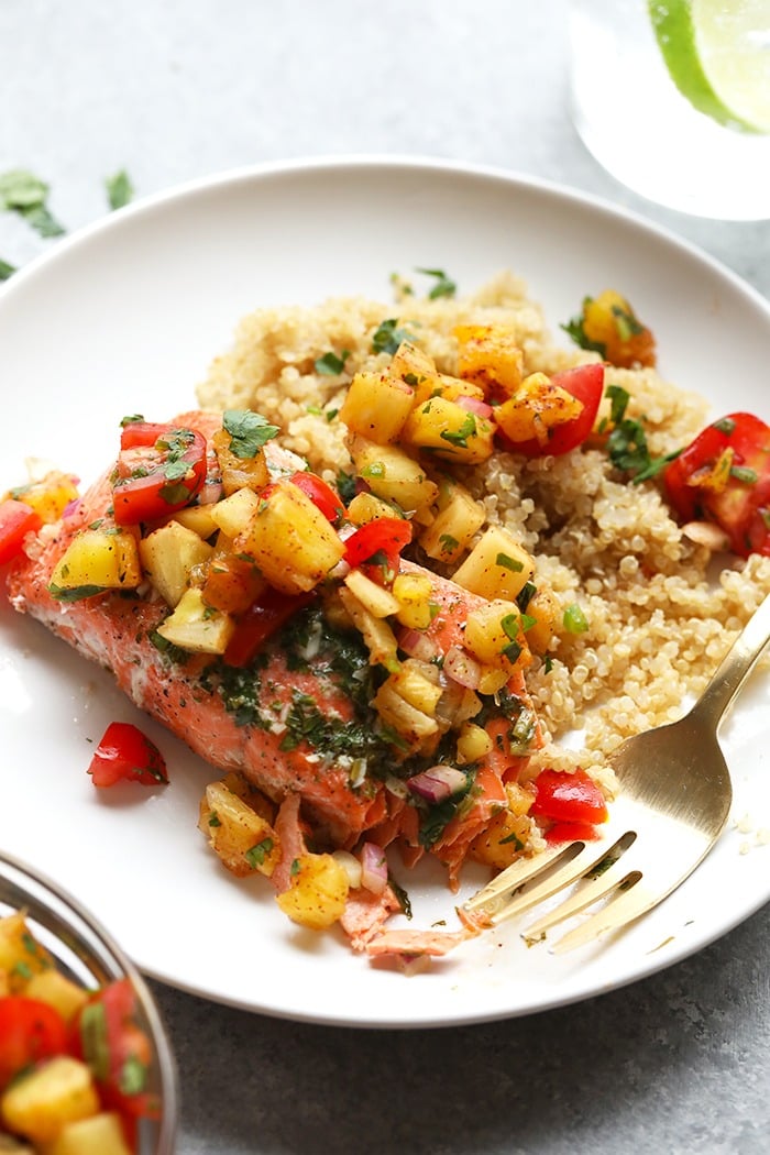 Grilled salmon on a plate with pineapple salsa.