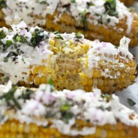 Mediterranean-style street corn grilled with parmesan cheese and herbs.