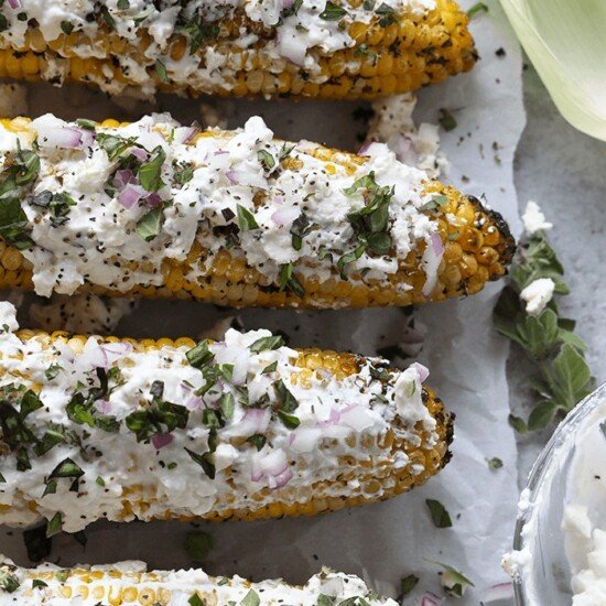 Mediterranean-style grilled corn with sour cream and herbs.