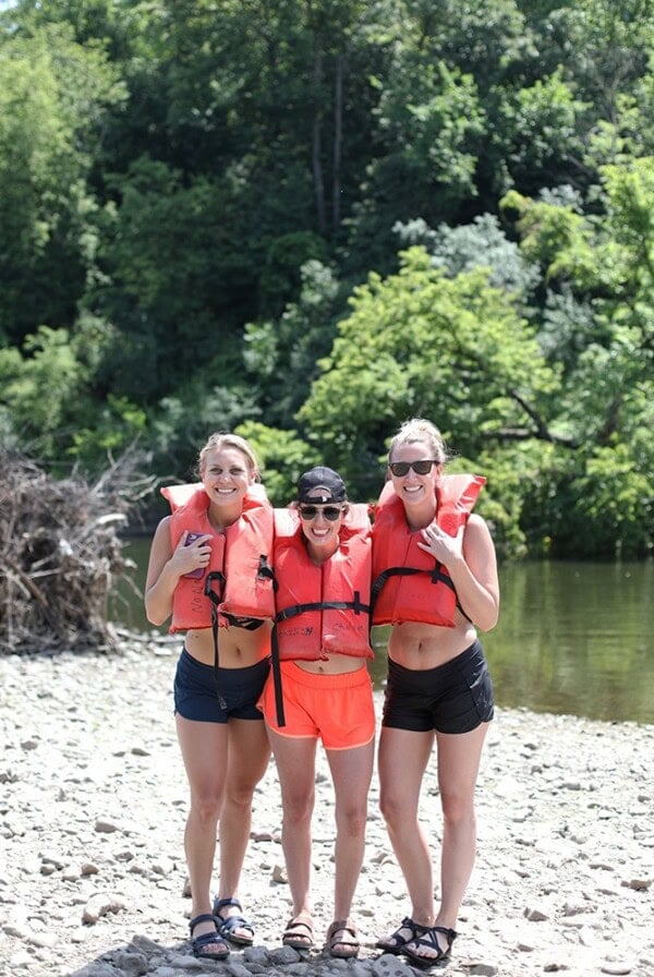 Three women canoeing on the Cannon River wearing life jackets.