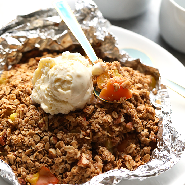 Peach season is here and this foil-pack peach crumble recipe on the grill is easy, delicious, and healthy! It's made with juicy peaches tossed in maple syrup and a yummy crumble topping, making it a gluten free fruit crumble and a healthy dessert recipe for the summertime!