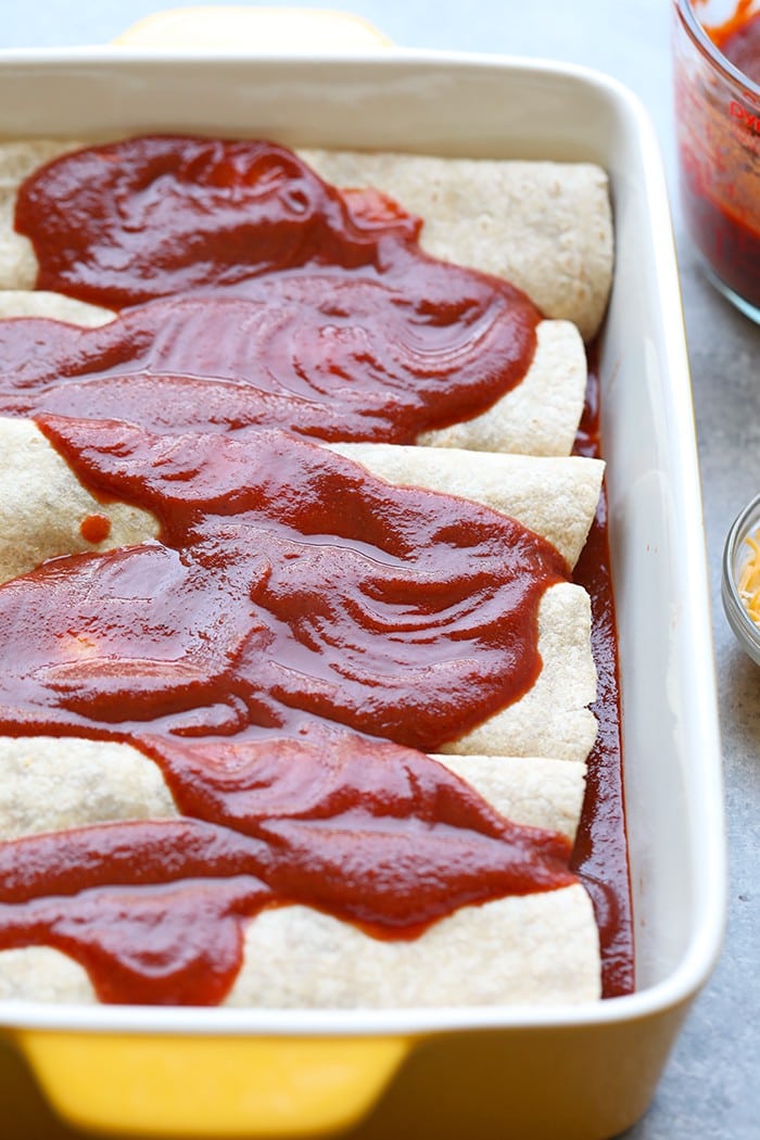 healthy enchiladas covered with homemade enchilada sauce in baking dish