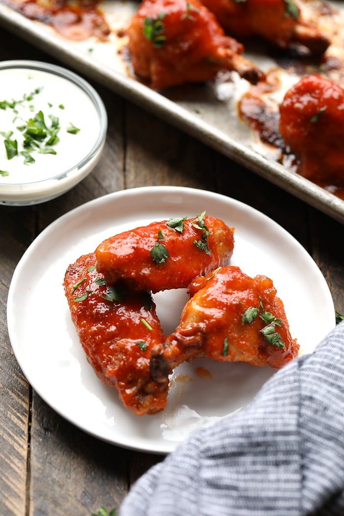 3 baked buffalo chicken wings on white plate