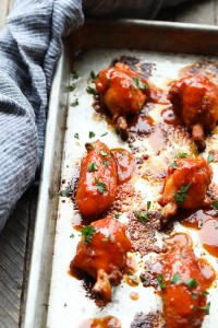 BBQ chicken wings being baked on a sheet.