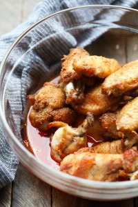 Baked chicken wings served in a bowl on a wooden table.