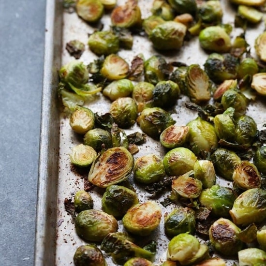 Roasted brussels sprouts with parmesan on a baking sheet.