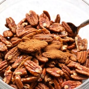 Roasted pecans in a glass bowl.