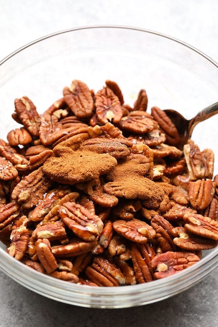 Maple roasted pecans with cinnamon in a mixing bowl. 