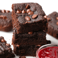 a stack of chocolate beet brownies with raspberry sauce.