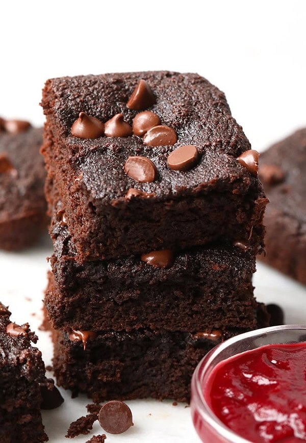 A stack of healthy chocolate brownies with a touch of raspberry jam.