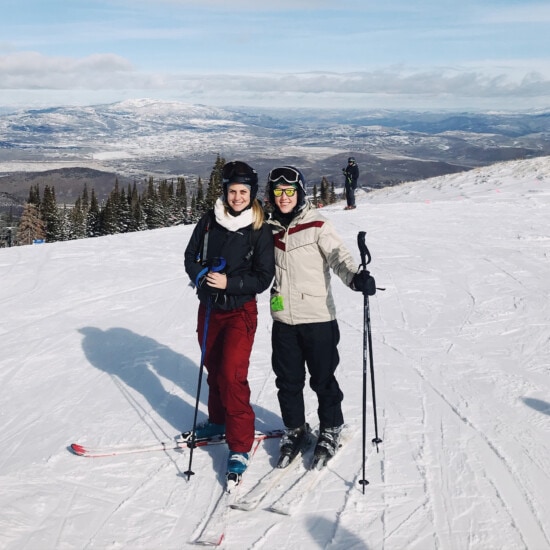 Two people posing for a photo on a Park City ski slope.
