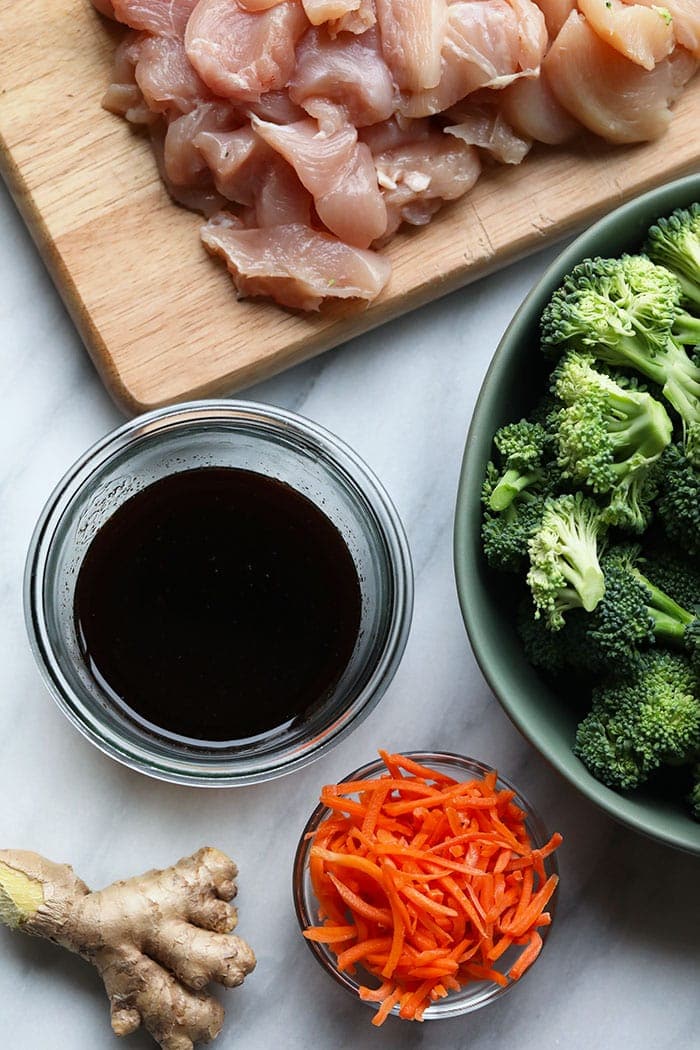ginger, soy sauce, broccoli, carrots, and chicken breast in bowls