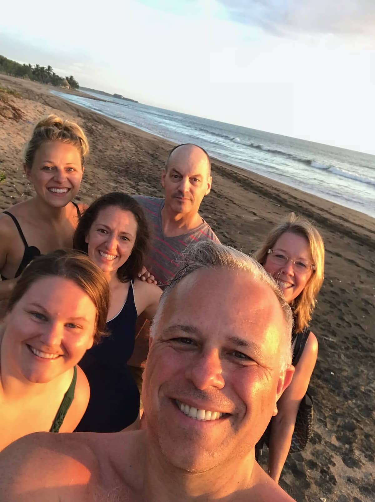 People takin a selfie on the beach. 