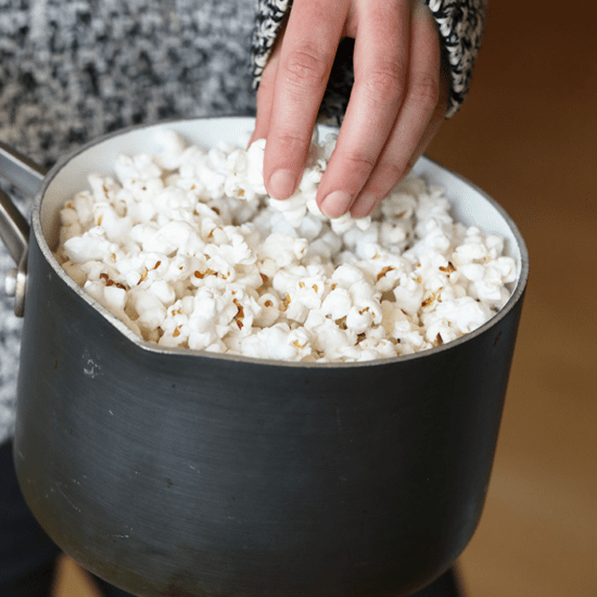 popcorn in pot with hand reaching for a handful