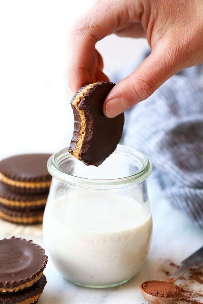 Dunking a nut butter cup into milk. 