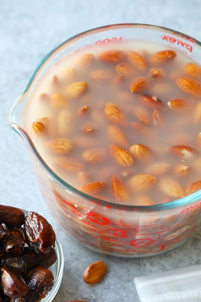 raw almonds being soaked in water to soften before making almond milk