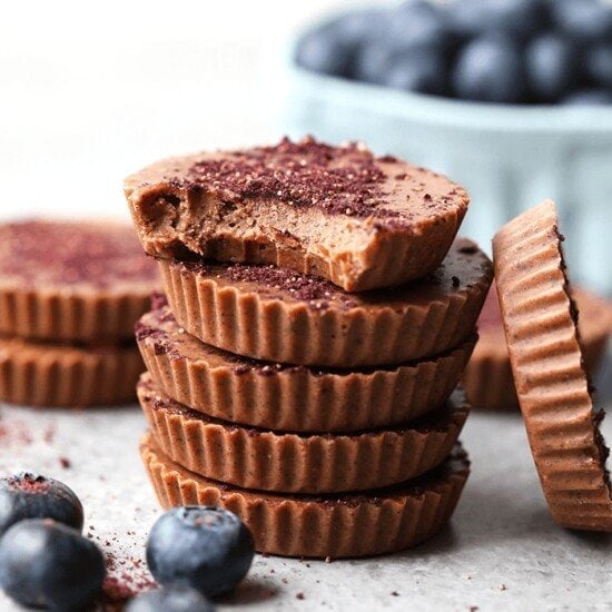 A stack of chocolate peanut butter fat bombs with blueberries.