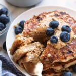 Protein-packed oatmeal pancakes with blueberries on a plate.