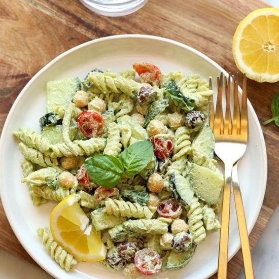A Greek pasta salad with chickpeas and lemon wedges.