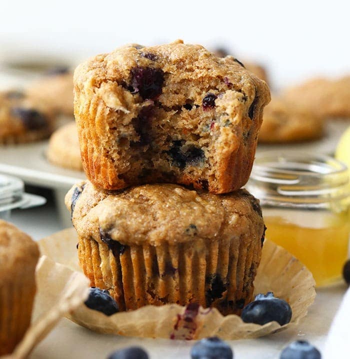 These healthy blueberry muffins are made with 100% whole grains and naturally sweetened with bananas and honey. At only 161 calories per muffin, you're going to love this healthy snack. healthy blueberry muffins stacked