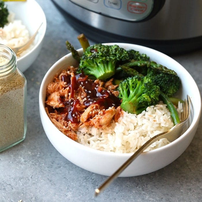 Shredded chicken served in a bowl with broccoli and rice