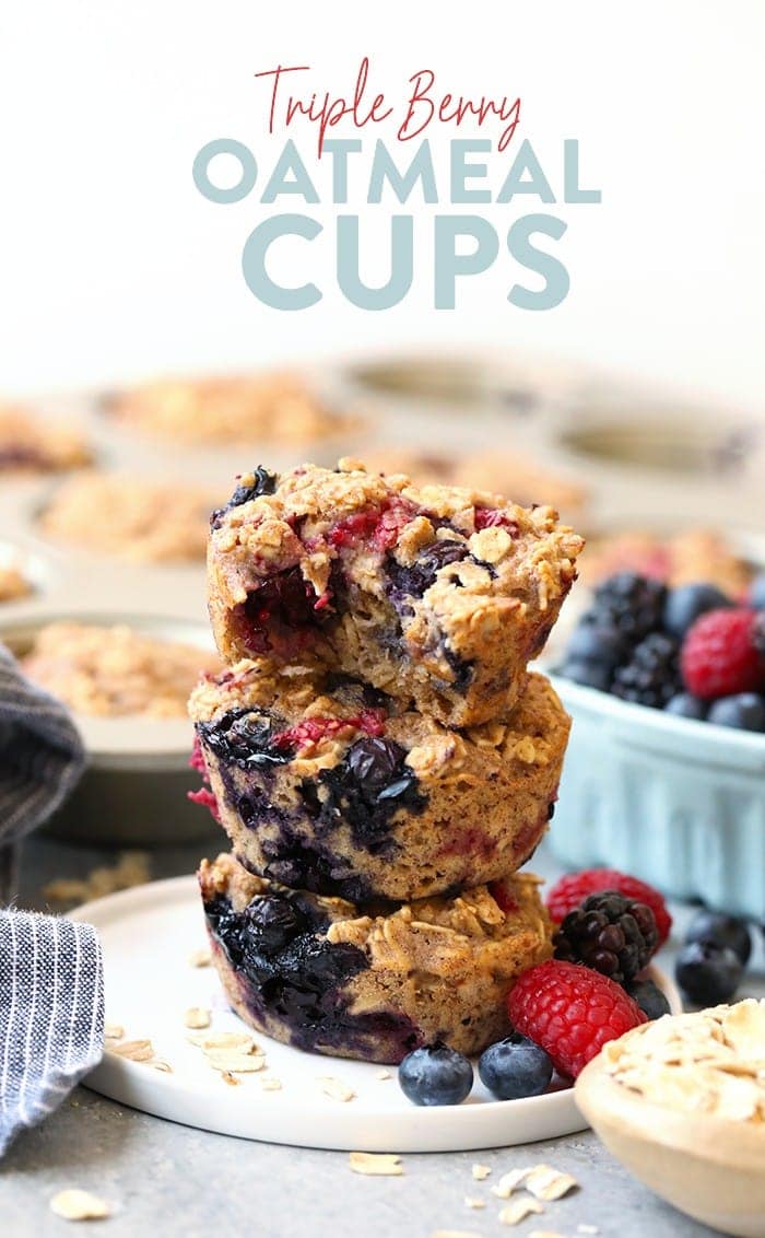 Get your meal prep on and make these easy Triple Berry Baked Oatmeal Cups for the week's breakfast. This baked oatmeal recipe is made with 3 kinds of berries, rolled oats, and ground oat flour making this a better-for-you breakfast or snack! triple berry oatmeal cups stacked with a bite taken out of them