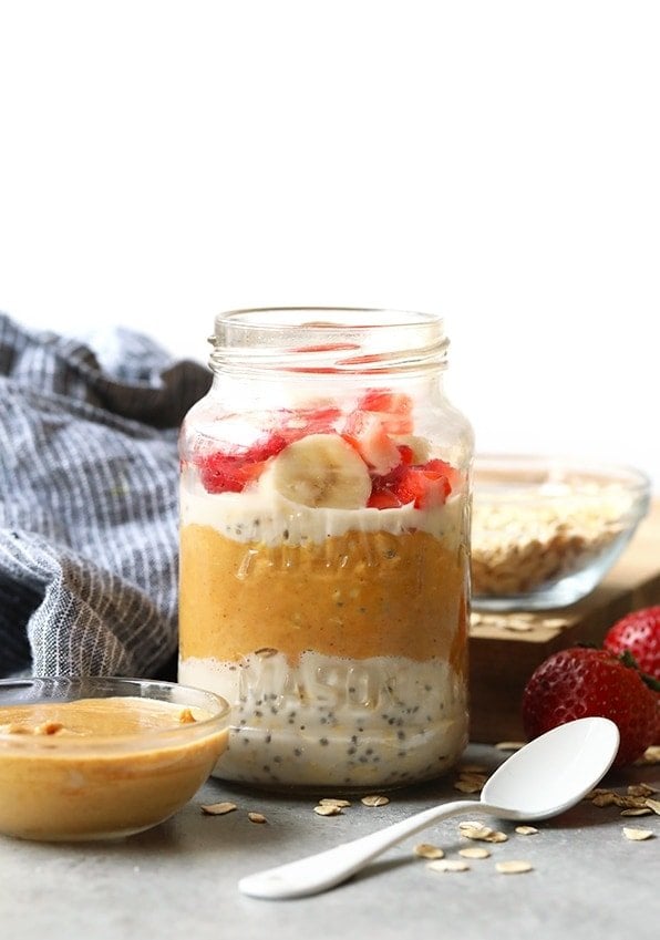 Vegan overnight oats in a jar with strawberries and peanut butter.