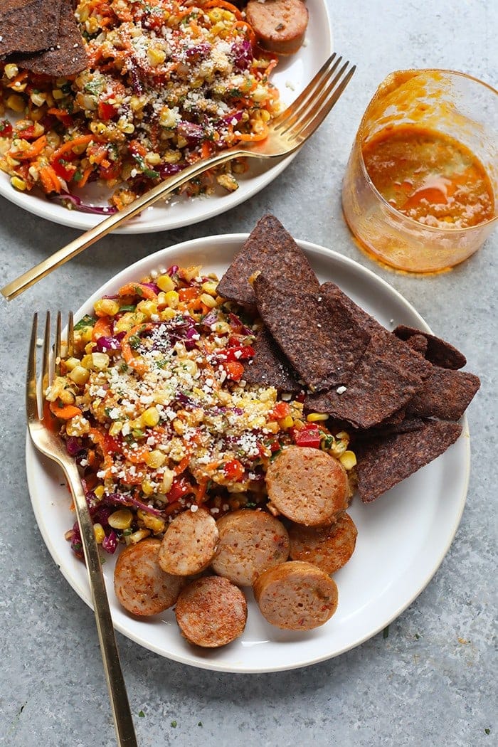 Corn salad with a side of sausage and chips