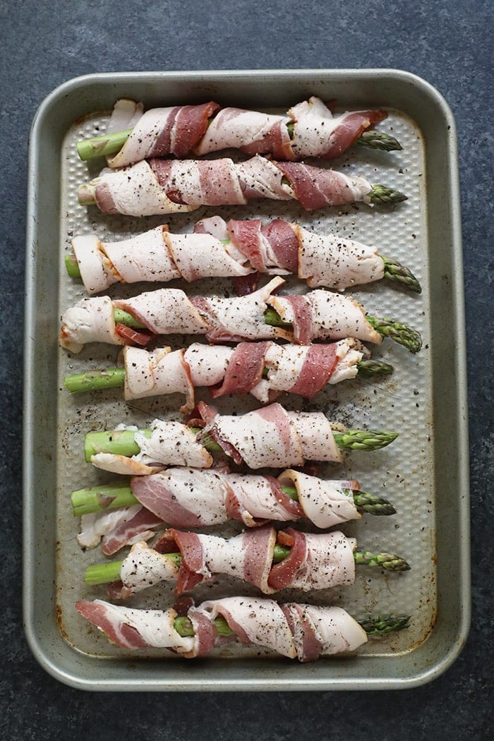 Bacon wrapped asparagus on a baking sheet