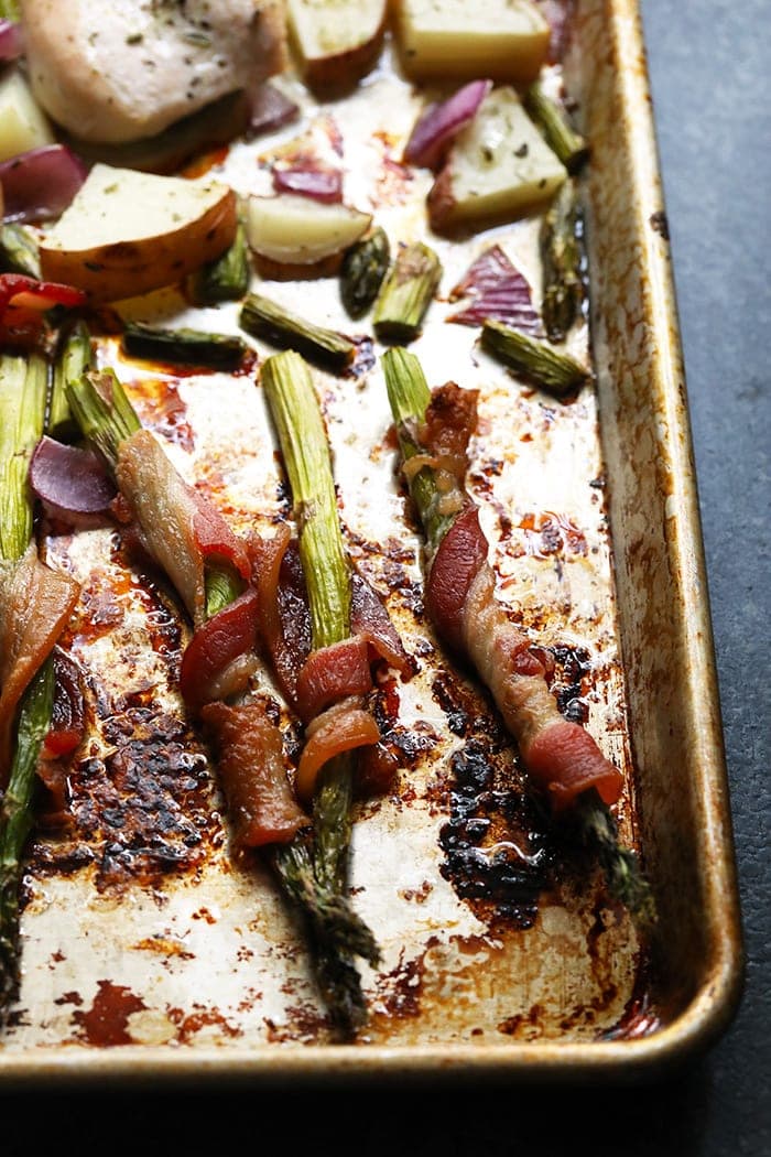 Roasted bacon-wrapped asparagus on a cooking sheet