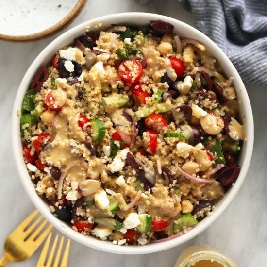 quinoa salad recipe in a white bowl with a fork.